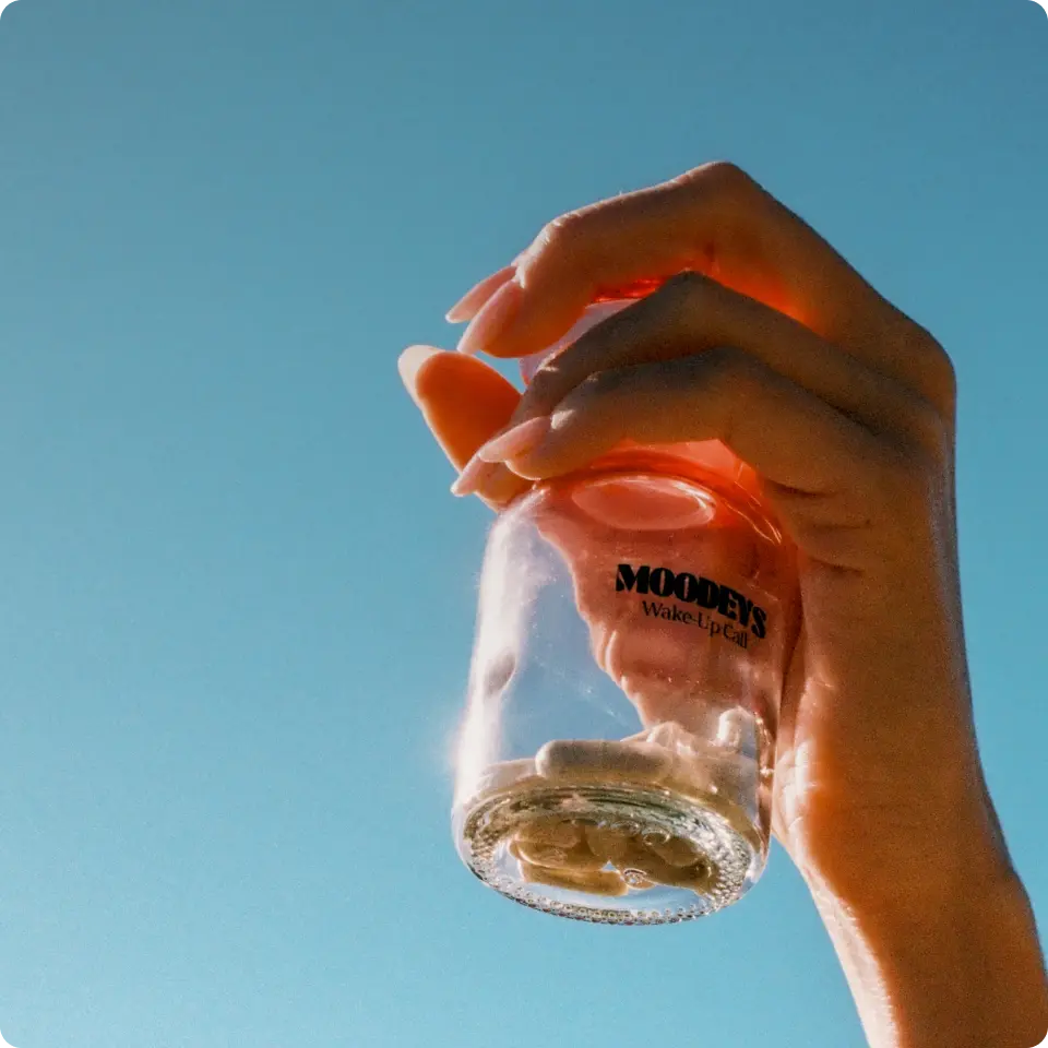 womans hand holding moodeys bottle in sunlight